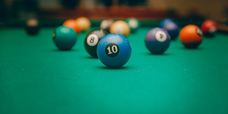 Colorful billiard balls on green felt pool table